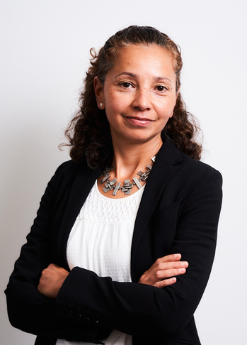 A professional portrait image of Jesse Lenson, a woman with crossed arms and a black blazer